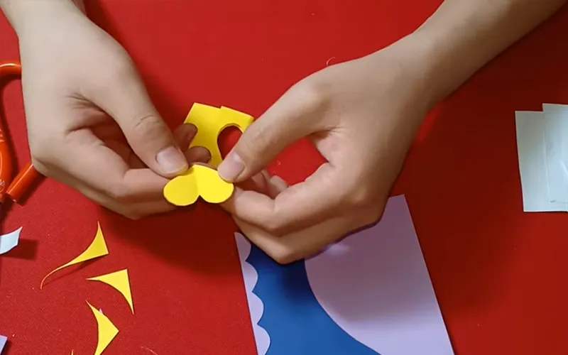 cắt phần giấy màu vàng thành hình trái tim